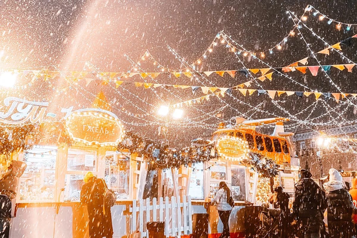 Illuminated Christmas market at night with festive stalls and decorations