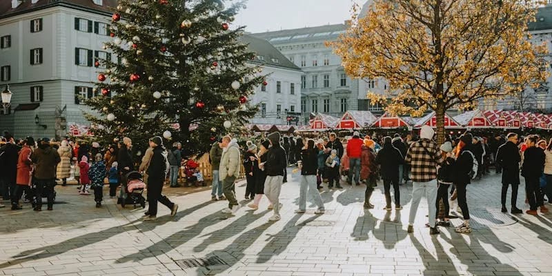 Marché de Noël sur une place européenne avec stands illuminés et décorations