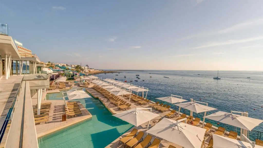 Piscina exterior y tobogán del AX ODYCY Hotel en Qawra, Malta